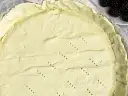 Surowe ciasto na tartę, z widocznymi dziurkami, czeka na wypełnienie. Tarta na kruchym spodzie czy na cieście francuskim?