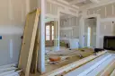 Remont w toku. Zastanawiasz się, jakie dokumenty wymaga nadzór budowlany podczas remontu? Na podłodze drzwi, materiały budowlane, narzędzia.