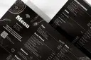 Czarne, eleganckie menu restauracji z rysunkami pizzy i sztućców. Zawiera sekcje: Zupy, Dania Główne, Makaron, Pizza.