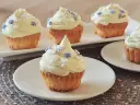 Babeczki z kremem i ozdobami w kształcie gwiazdek i kwiatków.