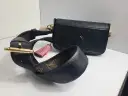 Elegancka, czarna louis vuitton torebka z ozdobnym, różowym pomponem i paskiem z monogramem.
