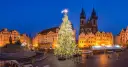 Jarmark bożonarodzeniowy w Pradze. Ogromna, oświetlona choinka na Rynku Staromiejskim, w tle gotycka architektura i zabytkowe kamienice.