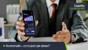 Mężczyzna w garniturze pokazuje smartfon z wykresem wydatków. Aplikacja Kontomatik współpracuje z wieloma bankami, ułatwiając zarządzanie finansami.