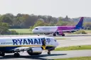 Samolot Ryanair na pierwszym planie, w tle samolot Wizz Air na pasie startowym.