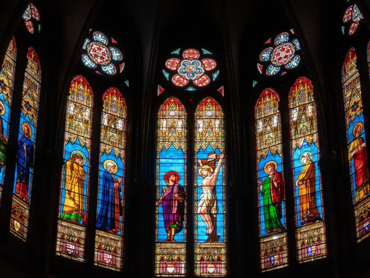 Magnifiques art vitraux d'une église, représentant des scènes bibliques avec des figures colorées sur fond bleu.