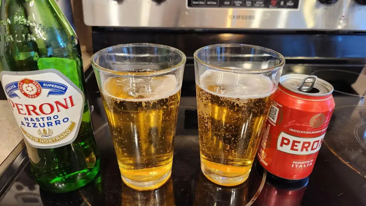 Dwa szklanki orzeźwiającego peroni piwo, obok zielona butelka i czerwona puszka. Idealne na włoskie popołudnie.