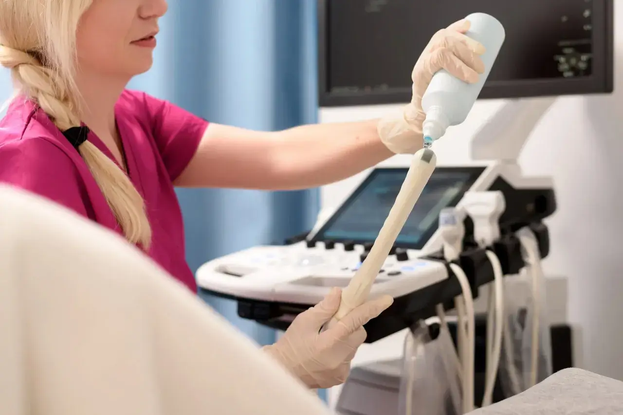Lekarka przygotowuje sondę USG, aplikując żel. Badanie oceni m.in. grubość endometrium normy.
