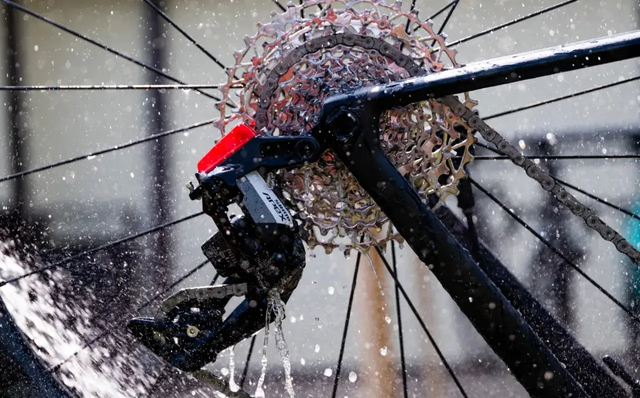 Błyszczące, elektryczne przerzutki SRAM Apex na rowerze, obmywane przez strumienie wody.