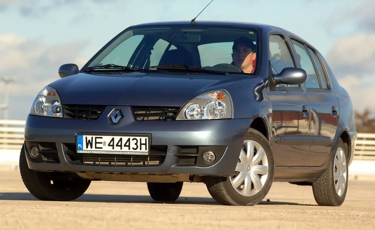 Ciemnogranatowy Renault Thalia 1.4 z kierowcą za kierownicą, zaparkowany na zewnątrz.