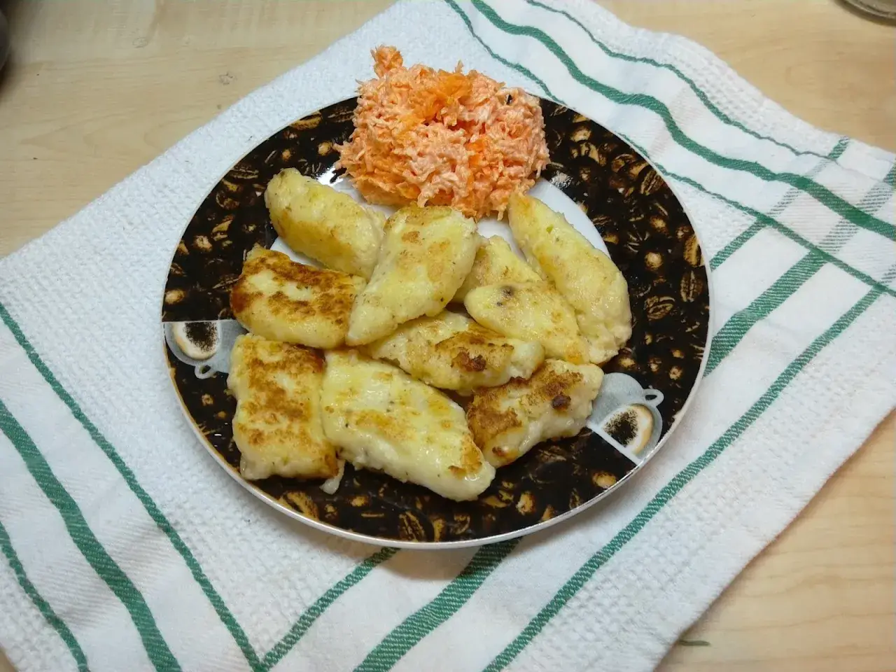 Usmażone pierogi ruskie z serem i ziemniakami, podane z surówką z marchewki.