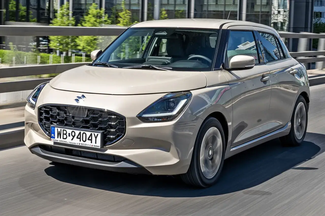 Nowy Suzuki Swift w beżowym kolorze, z nowoczesnym grillem i światłami LED. Sprawdź aktualne suzuki swift - ceny i oferty.