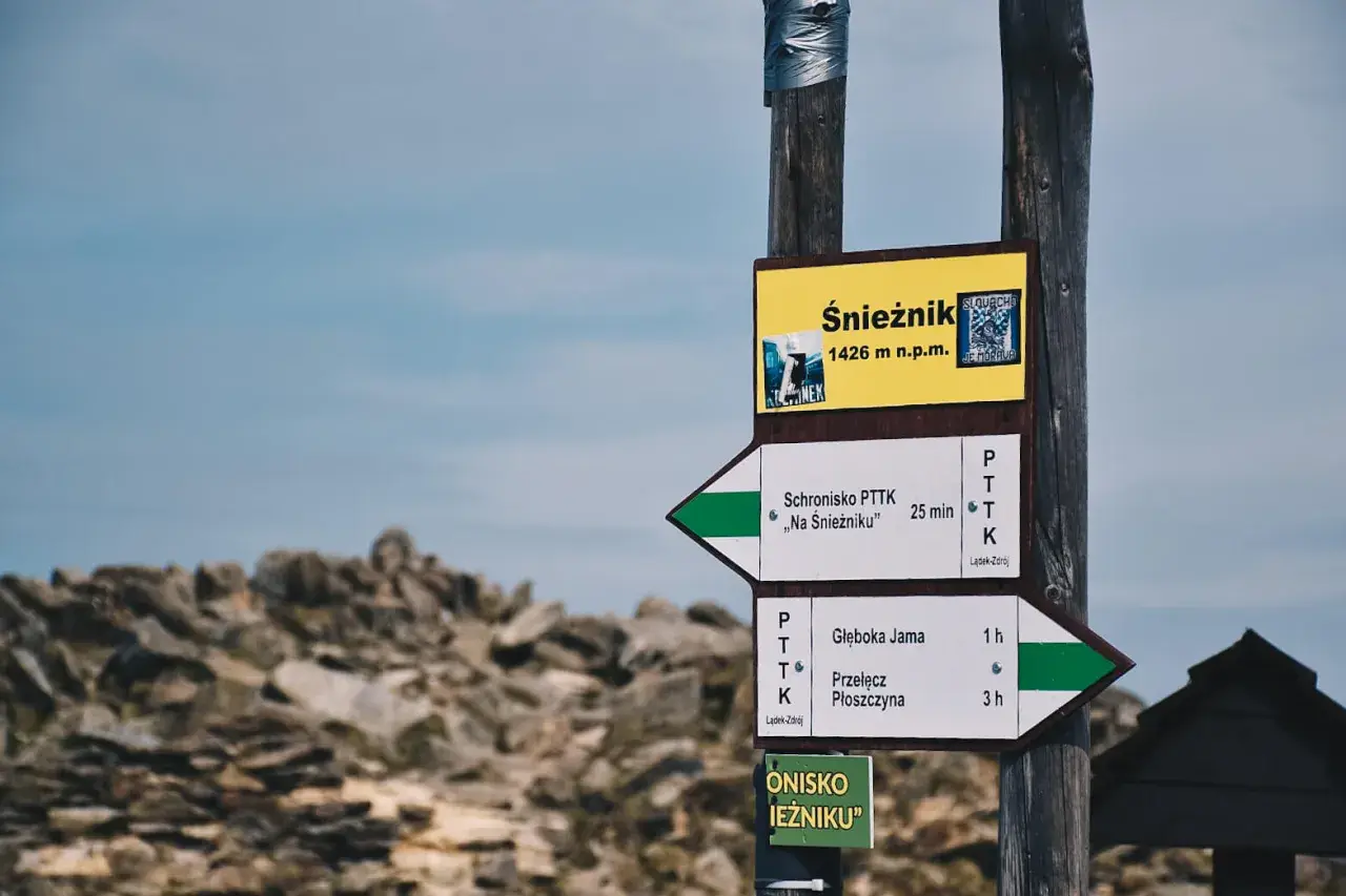 Znak drogowskazów na Śnieżnik, 1426 m n.p.m. Wskazuje drogę do schroniska "Na Śnieżniku" i na Przełęcz Płoszczynę.