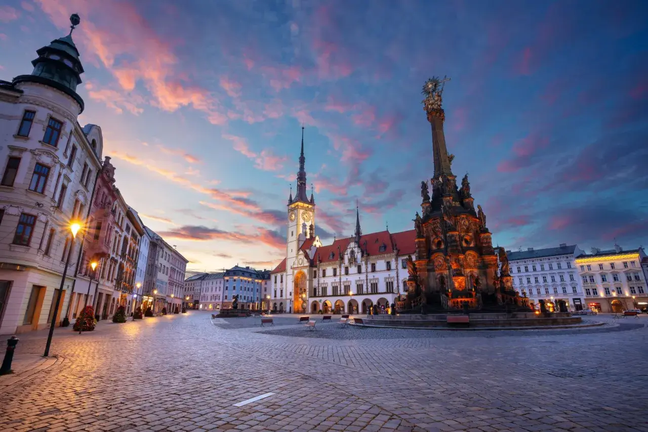 Rynek w Ołomuńcu, perle Moraw Południowych, o zachodzie słońca. Majestatyczna kolumna Trójcy Świętej i ratusz w blasku lamp.