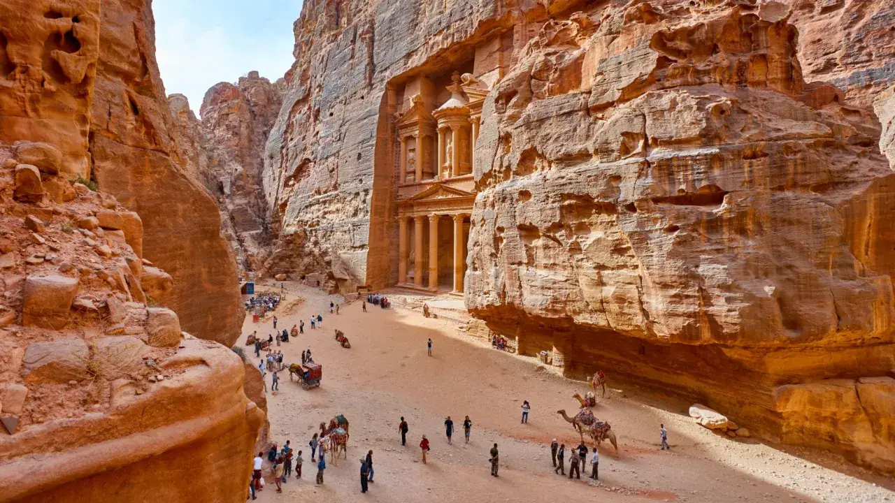 Skaliste wąwozy Petry, Jordania. Wspaniałe widoki, idealne na jordania loty. Turyści i wielbłądy w drodze do Skarbca.
