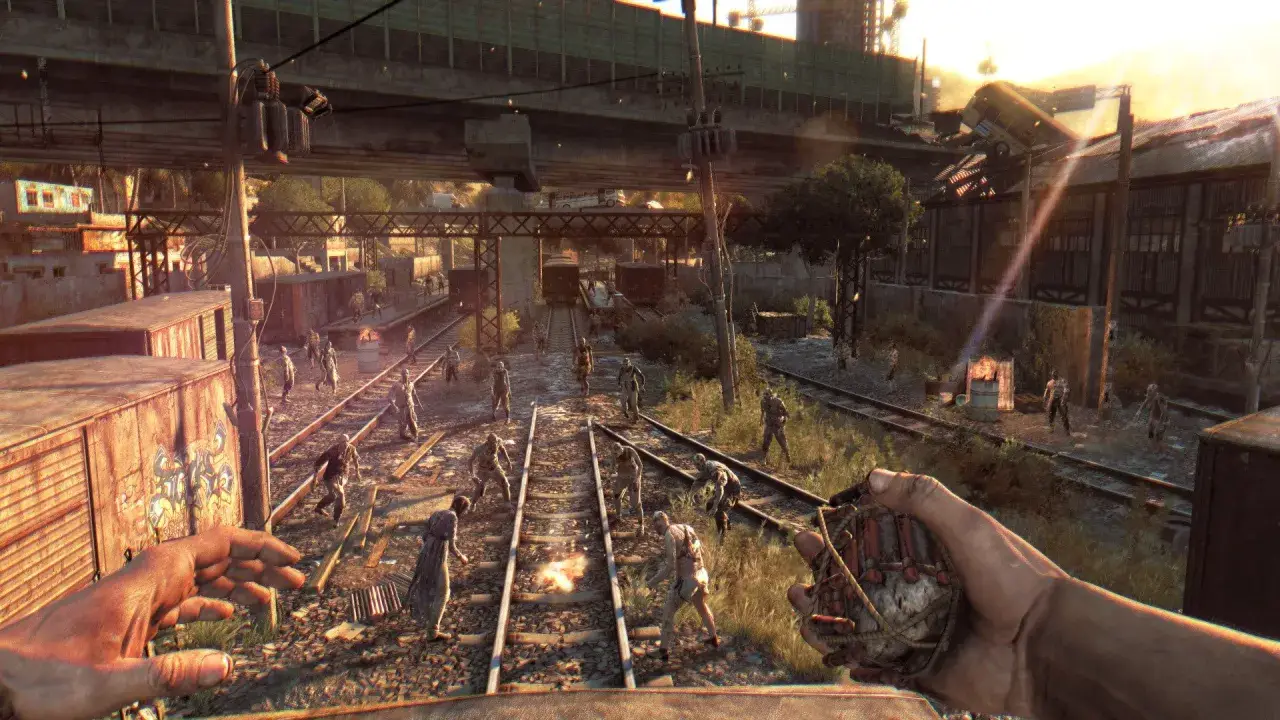Gracz trzyma granat, otoczony przez hordę zombie na torach kolejowych. To scena z gry Dying Light, gdzie wymagania sprzętowe są kluczowe dla płynności rozgrywki.