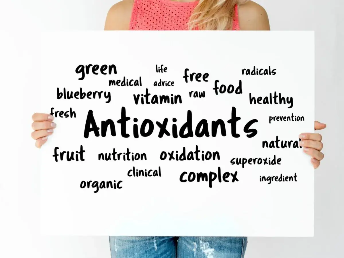 Tablica z napisem "Antioxidants" otoczona słowami kluczowymi, takimi jak "free radicals", "healthy food", "vitamin", "fruit", "blueberry".