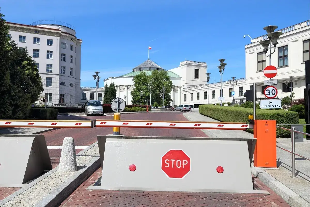Przed Sejmem RP, gdzie dyskutuje się, ile wynosi dieta poselska, szlaban i znak STOP.