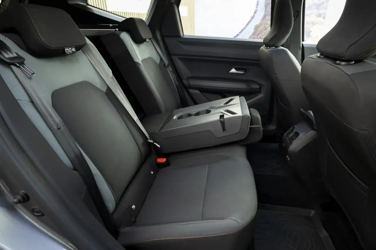Interni Dacia Bigster: sedili posteriori in tessuto grigio e nero, bracciolo centrale ribaltabile con portabicchieri.