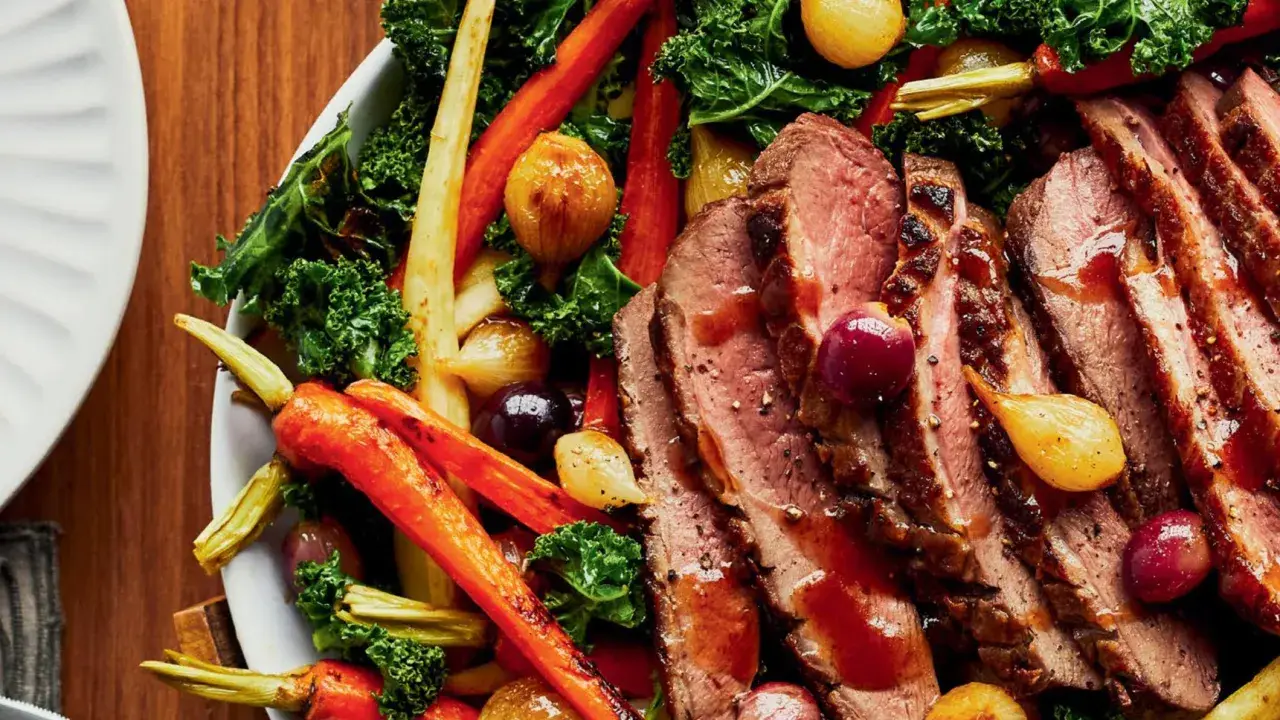 Tranches de magret de canard juteux, accompagnées de carottes rôties, d'oignons grelots et de chou frisé. Un plat savoureux et coloré.