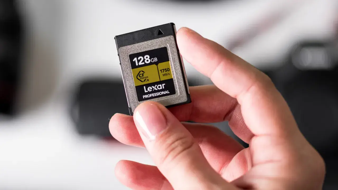 Dłoń trzyma kartę pamięci Lexar Professional 128GB CFexpress B, jedną z najszybszych klas kart pamięci.