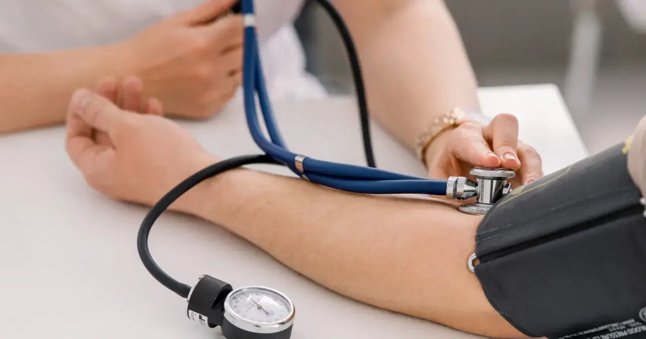 Lekarz mierzy ciśnienie pacjentowi. Wynik wskazuje ciśnienie rozkurczowe powyżej 100, co wymaga dalszej diagnostyki.