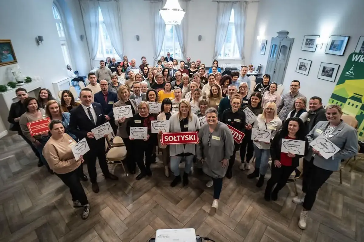Grupa osób trzyma tabliczki z napisami, m.in. "SOŁTYSKI", "Podnosimy wyzwania", "Ale ENERGIA!".
