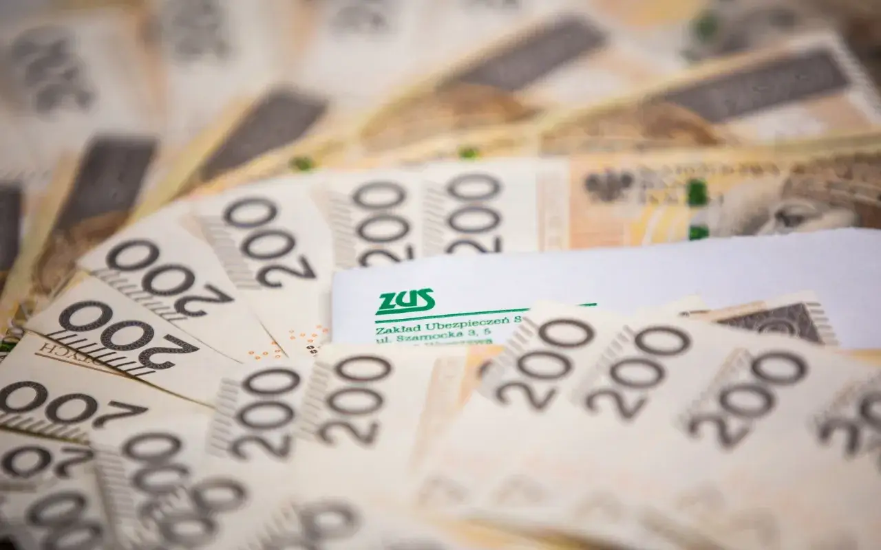 Polskie banknoty 200 zł i dokument ZUS. Ilustracja do przykładów przeliczenia emerytury kapitałowej na emeryturę powszechną.