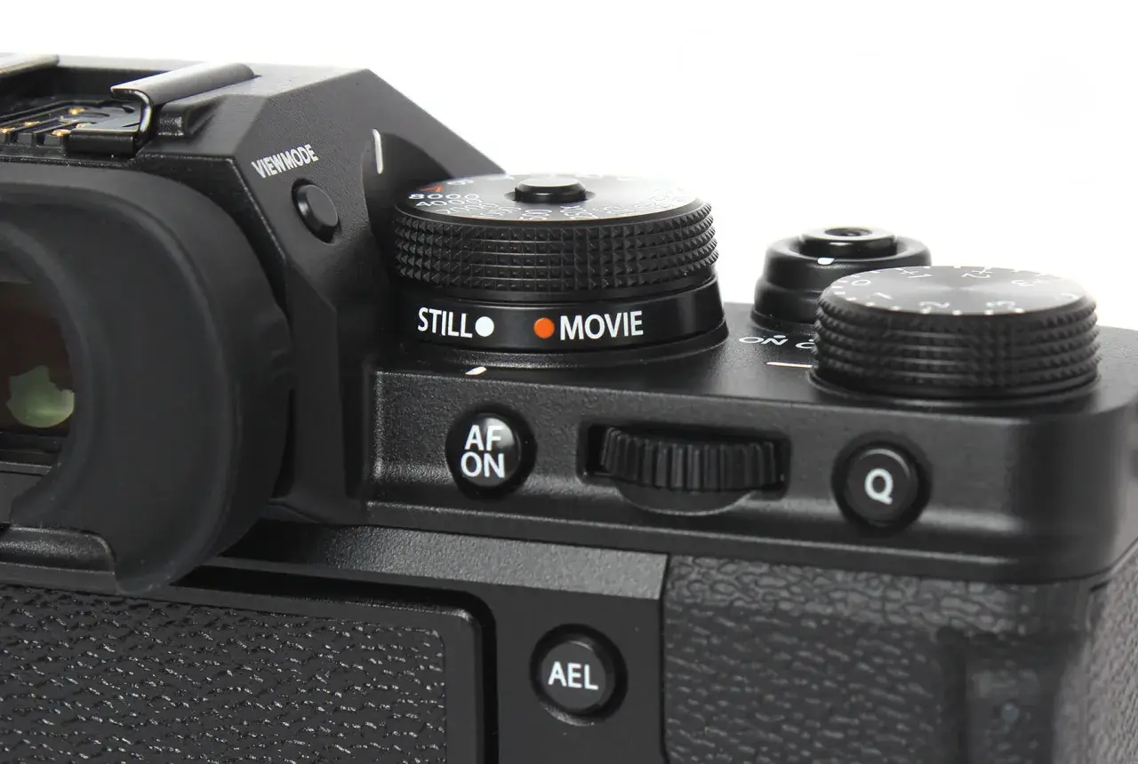 Część aparatu Fujifilm xt3 z pokrętłem wyboru trybu "STILL" i "MOVIE", przyciskiem "AF ON" i pokrętłem sterującym.