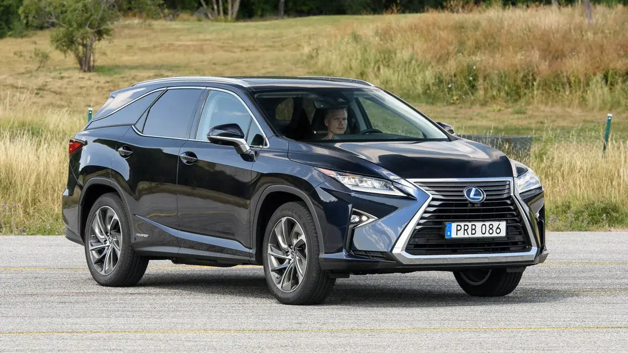 Mörkblå Lexus RX 450h körs på en väg, föraren ser ut att ha ett lexus rx 450h problem.