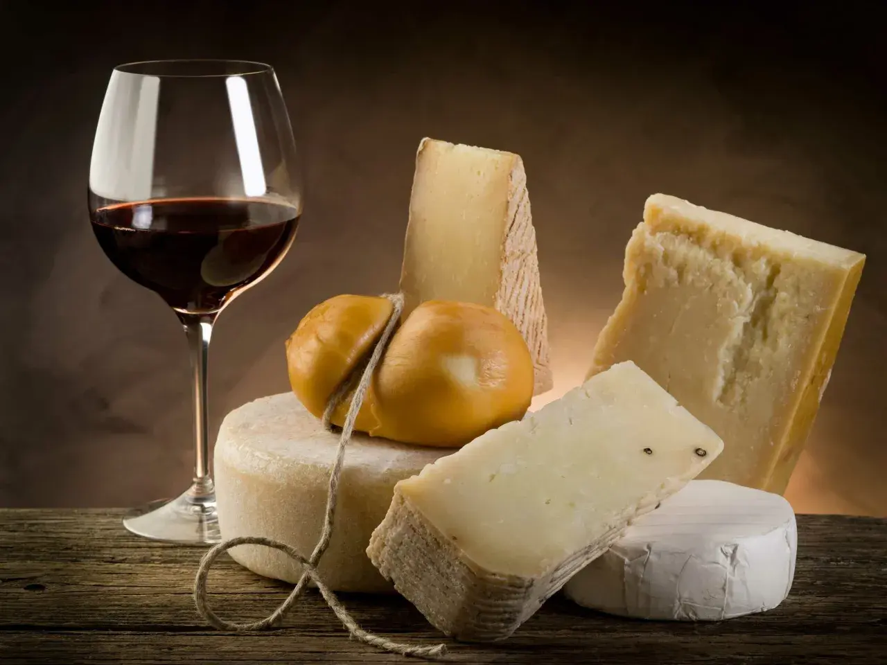 Un verre de vin rouge et une sélection de fromages, un accord parfait pour savoir quel vin avec le fromage.