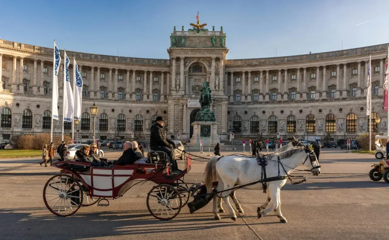 Wiedeń co zobaczyć: przejażdżka dorożką przed Hofburgiem, imponującym pałacem cesarskim.