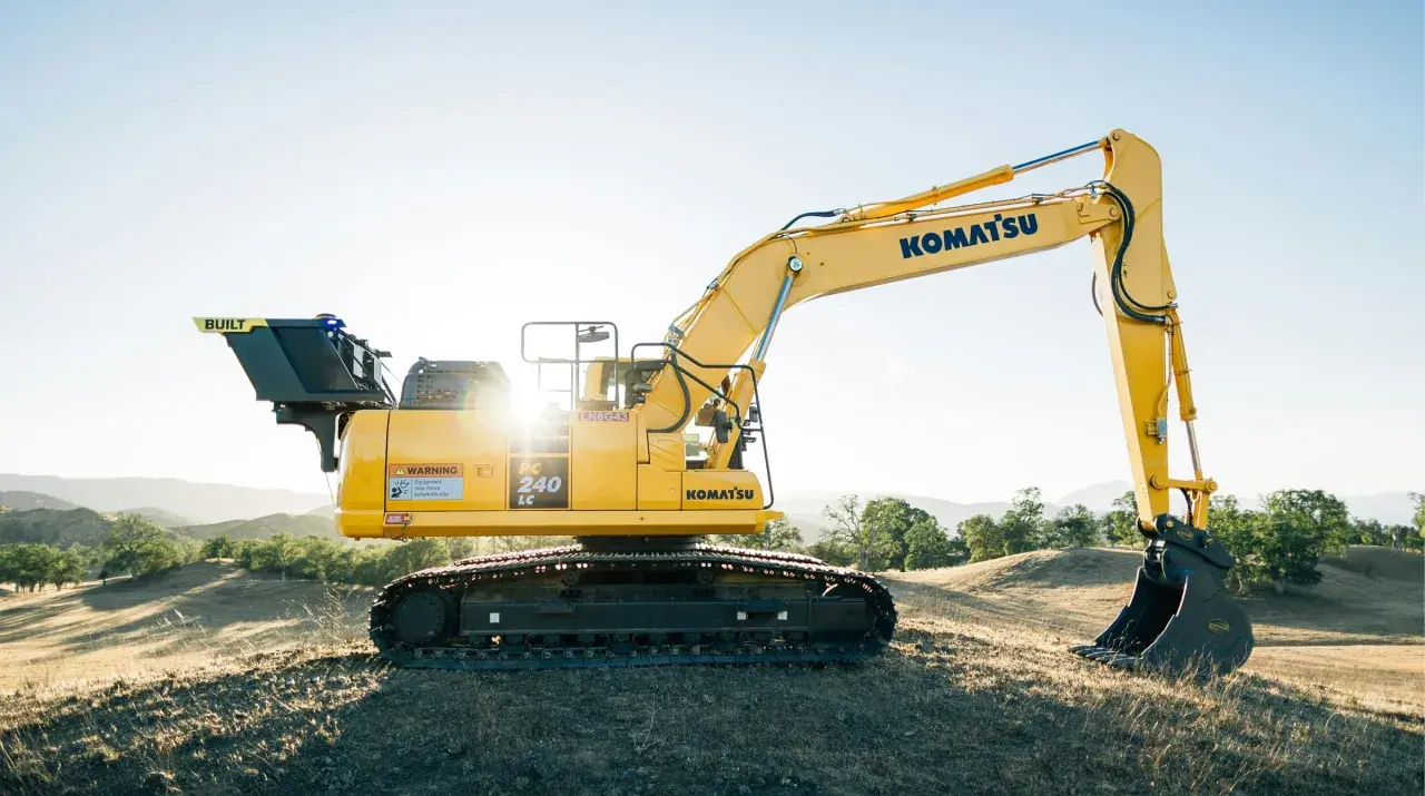 Żółta koparka Komatsu PC 240 LC na wzgórzu. Idealna do leasingu maszyn budowlanych.