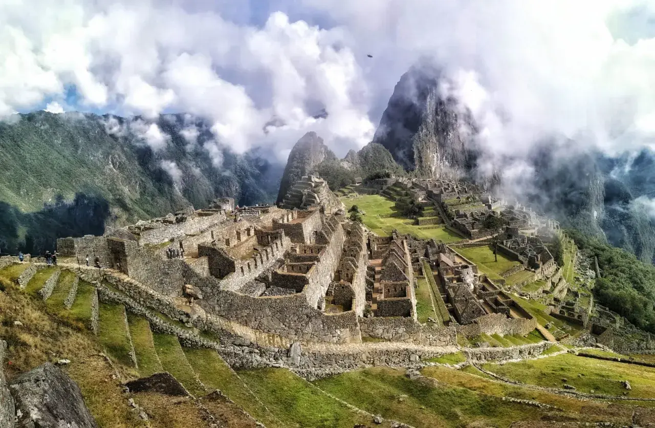Niesamowita wycieczka do Machu Picchu. Ruiny Inków w chmurach, otoczone zielonymi wzgórzami i majestatycznymi szczytami Andów.