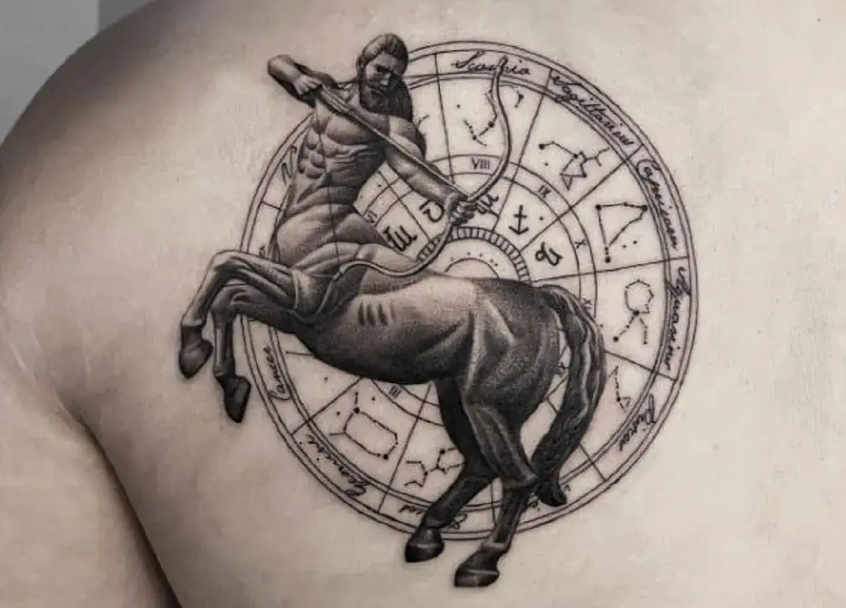 Tatuaż strzelec: centaur z łukiem i strzałą na tle koła zodiaku.