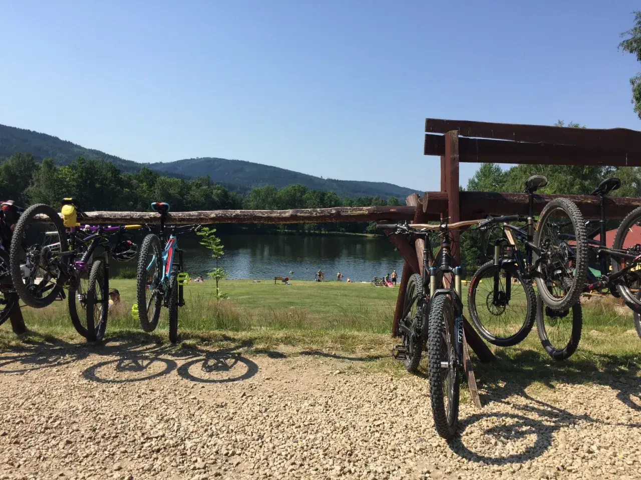 Rowerowe przygody czekają! Wiele rowerów gotowych do podboju tras rowerowych Świeradów Zdrój, nad jeziorem z plażowiczami.