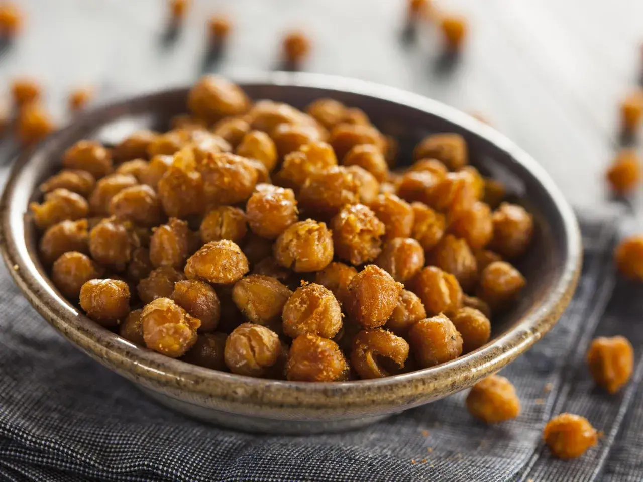 Un tazón lleno de garbanzos fritos crujientes y dorados, perfectos para un snack saludable.