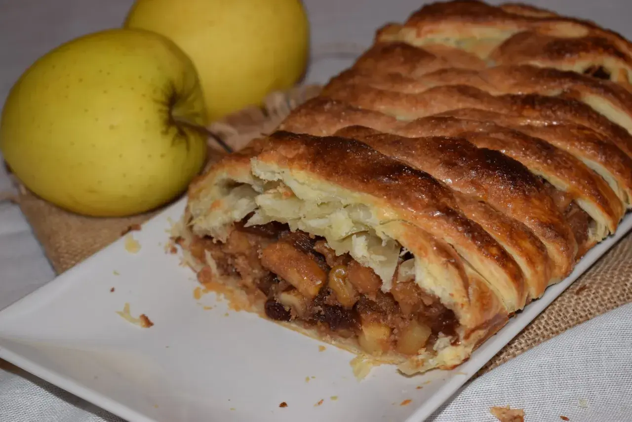 Strudel de manzana con hojaldre dorado y crujiente, relleno de trozos de manzana y pasas. ¡Perfecto para tu próxima receta!