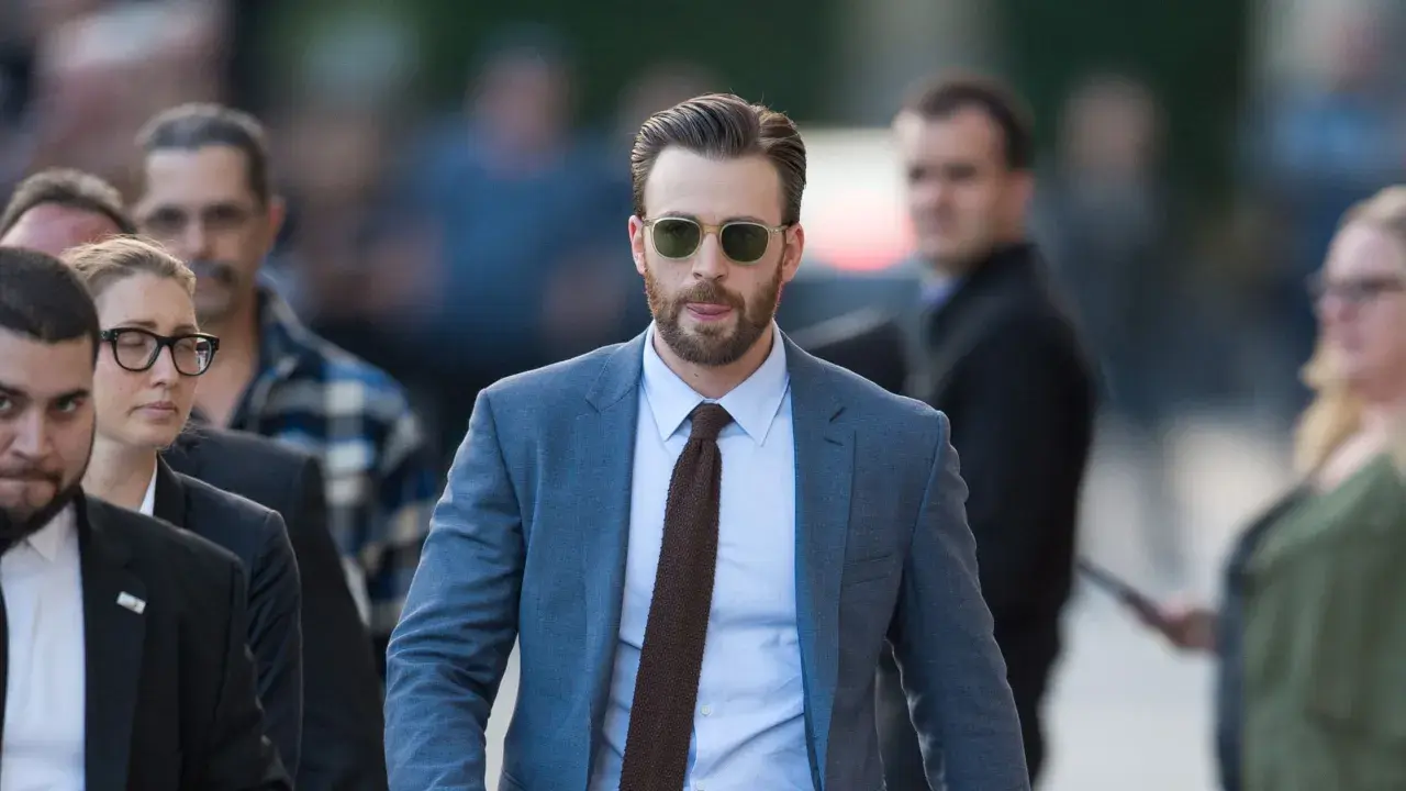 Chris Evans trägt einen blauen Anzug mit einem hellblauen Hemd und einer braunen Krawatte. Ein brauner Anzug kombiniert mit dieser Krawatte wäre auch stilvoll.