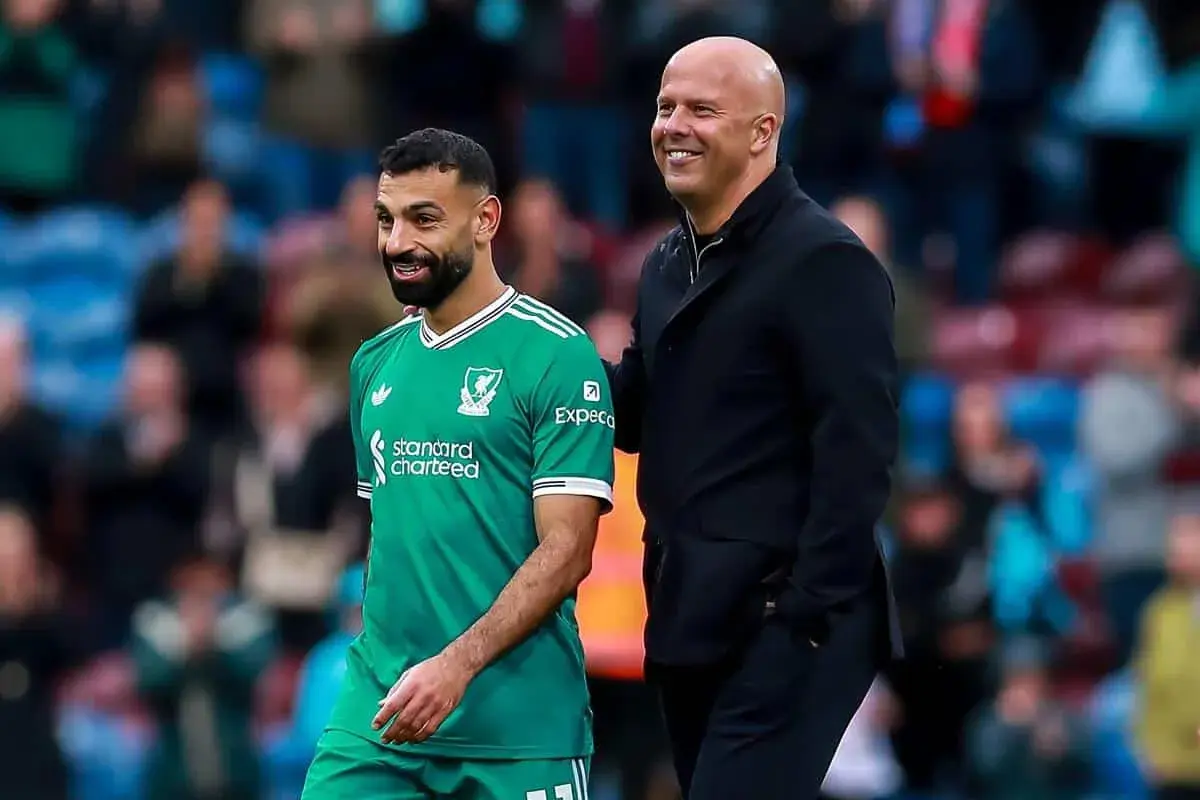 Piłkarz Liverpoolu w zielonej koszulce i łysy mężczyzna w czarnej kurtce uśmiechają się. To może być moment po udanych transferach Liverpoolu.