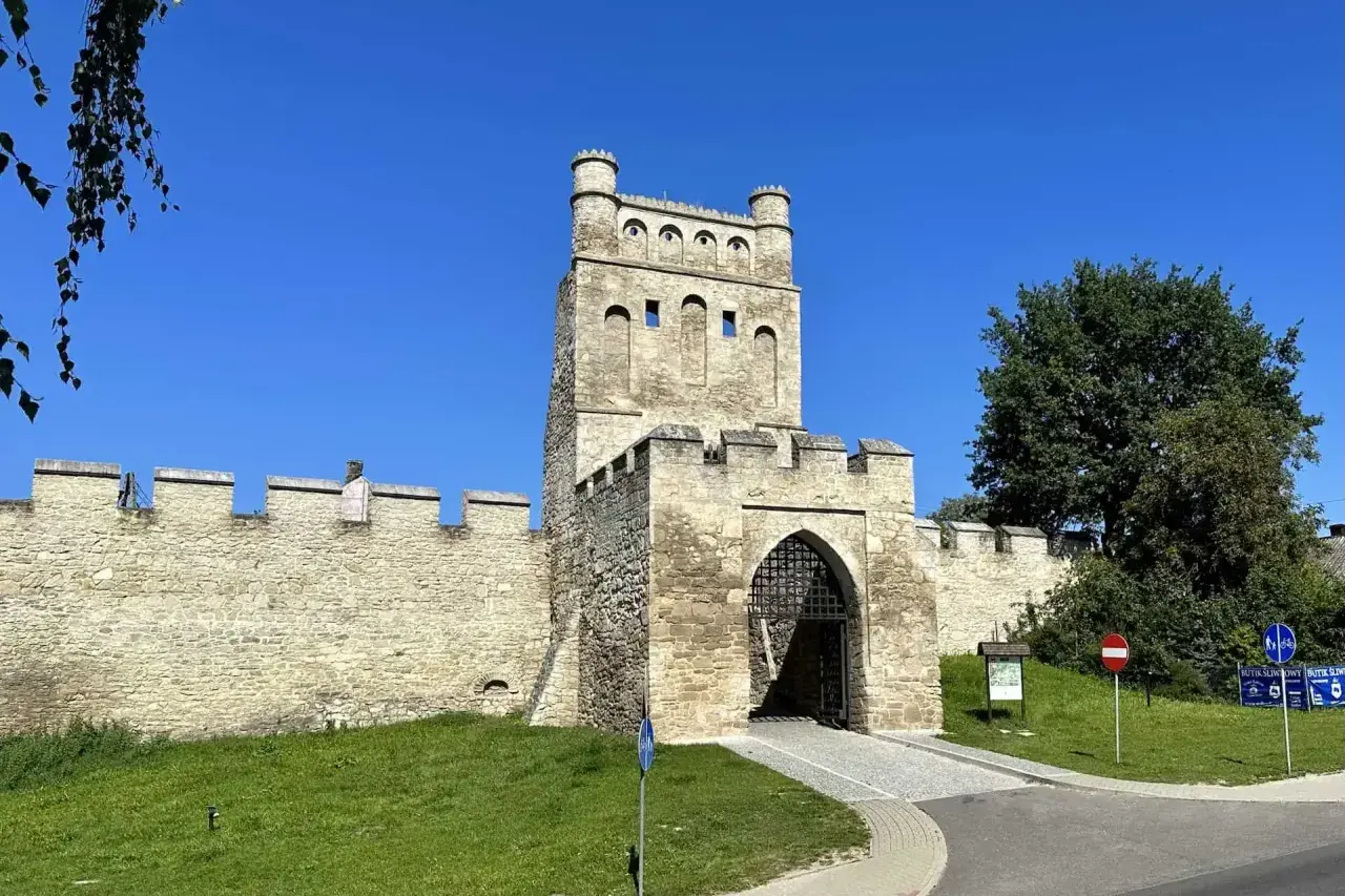 Kamienna brama z wieżą, otoczona murami obronnymi, przypomina polskie Carcassonne.