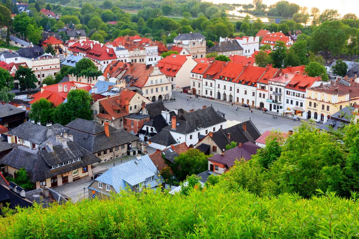 Urokliwe miasteczko z czerwonymi dachami, idealne na weekend w Lubelskiem. Zieleń otacza zabytkowe kamienice.