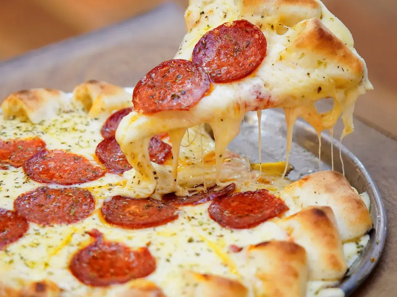 Pizza de pepperoni con queso mozzarella derretido y estirándose.