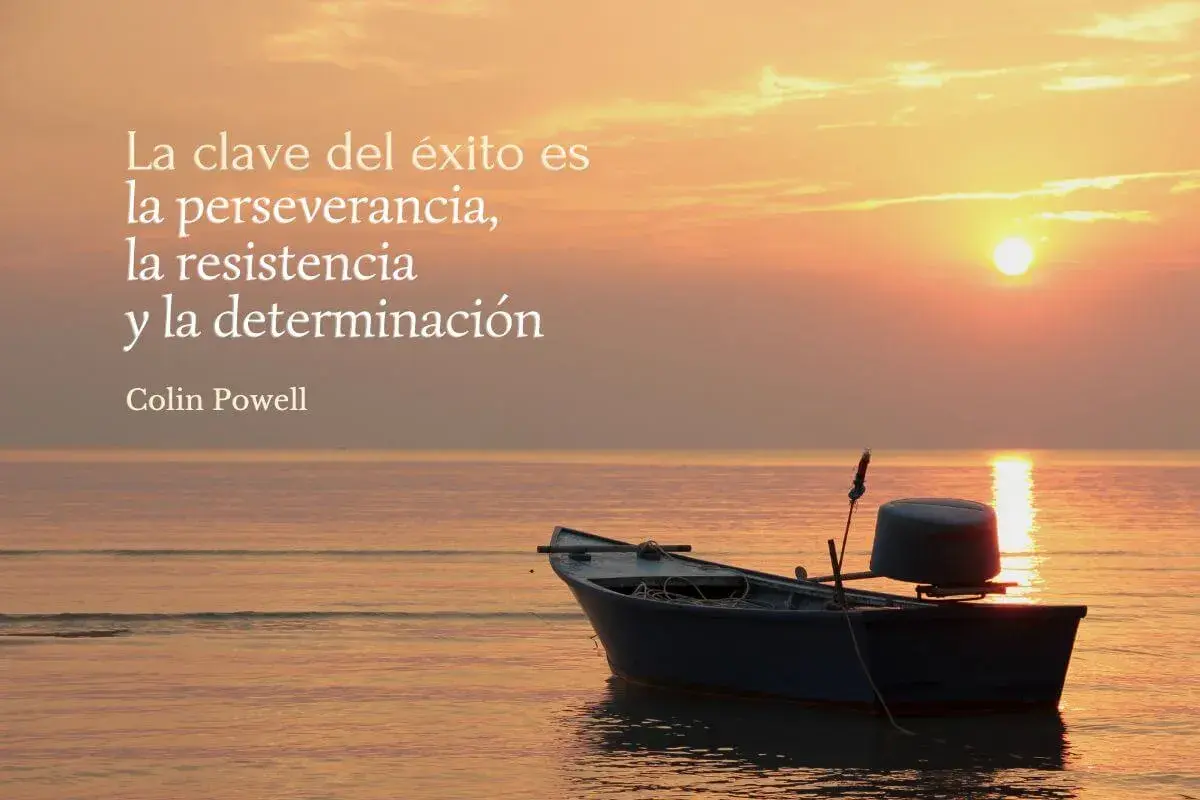 Barco solitario al atardecer, con frases de resiliencia: "La clave del éxito es la perseverancia, la resistencia y la determinación." - Colin Powell.