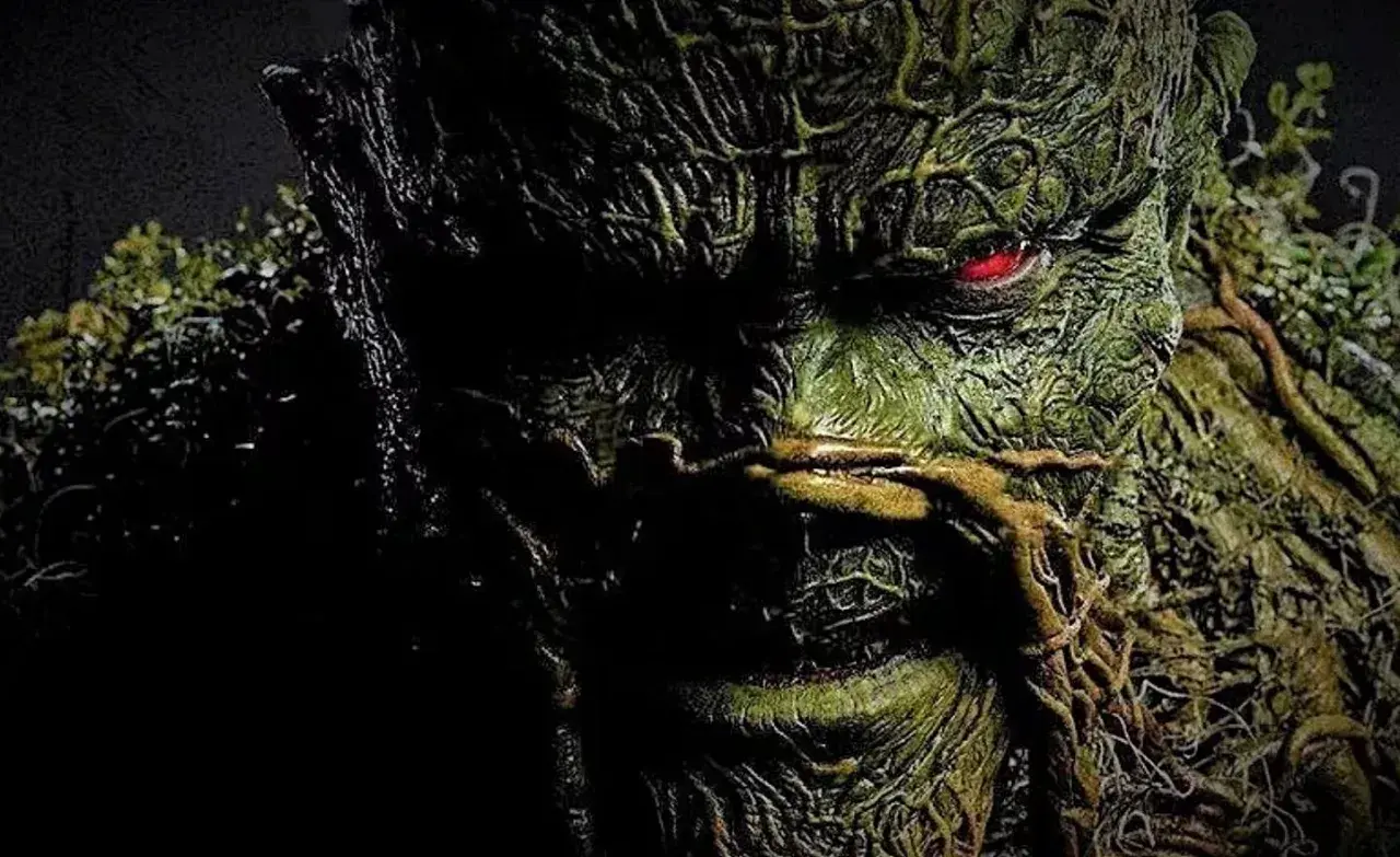 Gros plan sur le visage terrifiant de Swamp Thing, avec son œil rougeoyant. L'image évoque la saison 2 de Swamp Thing.