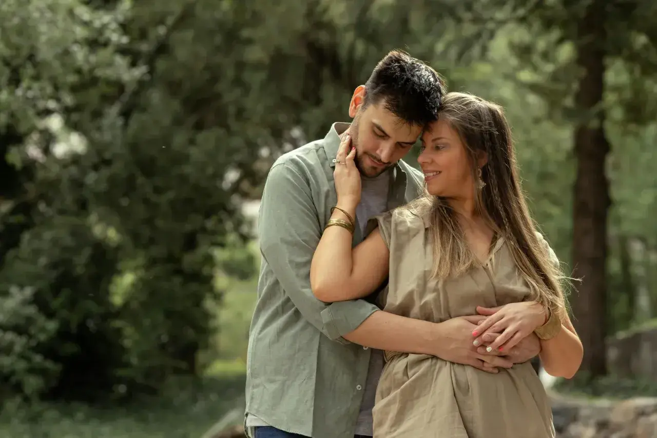 Coppia abbracciata in un parco, un momento di tenerezza che racchiude il vero amore significato.