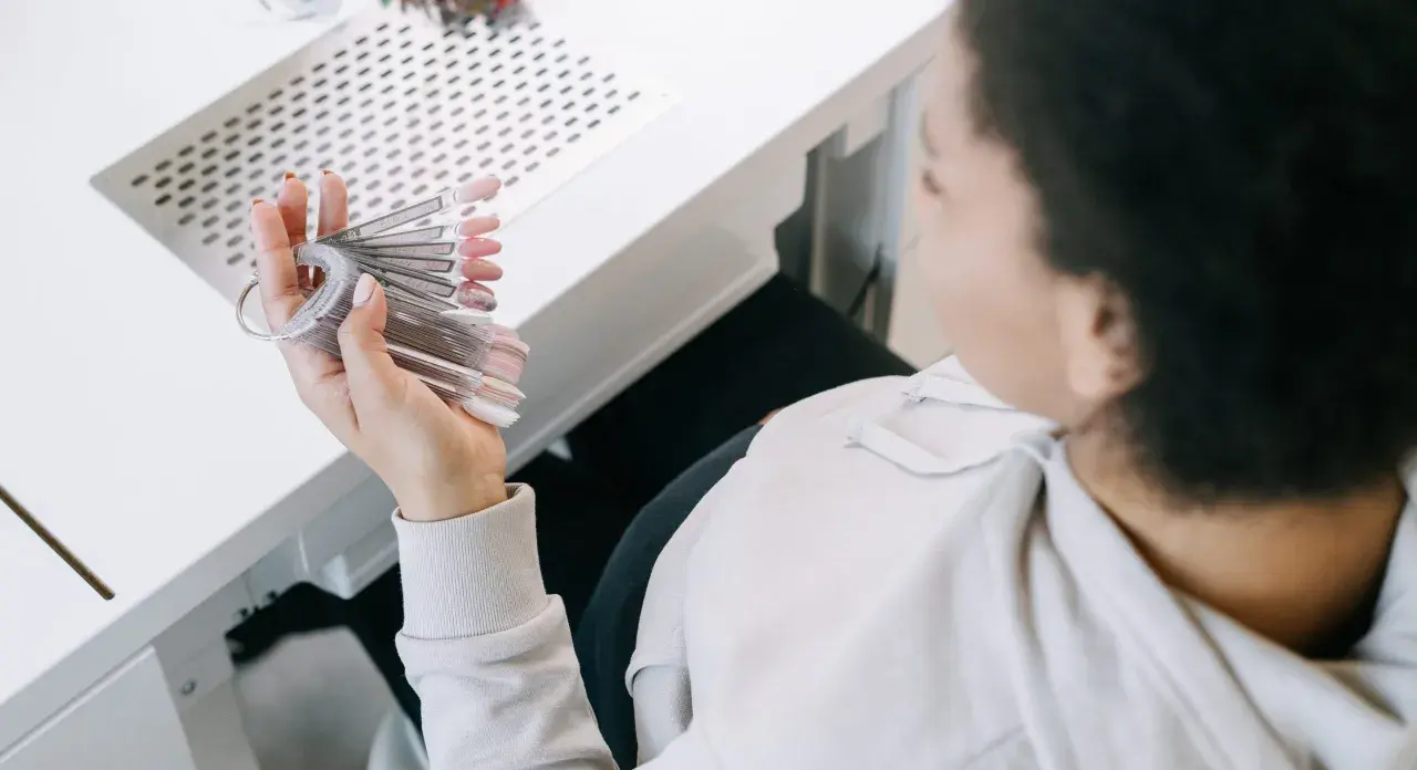 En gravid kvinna väljer nagellack från en provkollektion.