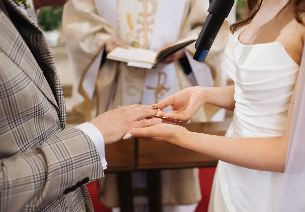 Panna Młoda zakłada obrączkę na palec Pana Młodego. Ceremonia ślub jednostronny w kościele.