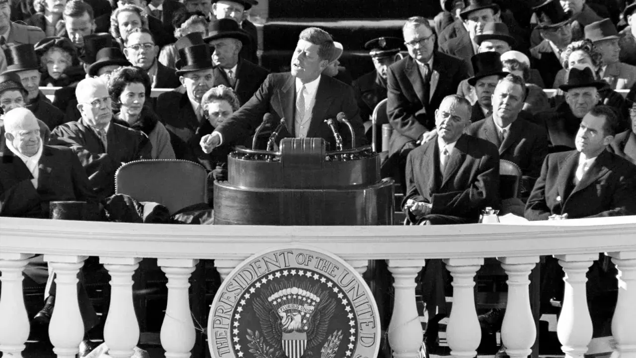 John F. Kennedy's inspiring **leadership style** is evident as he addresses a crowd, embodying youthful vigor and a call to action.