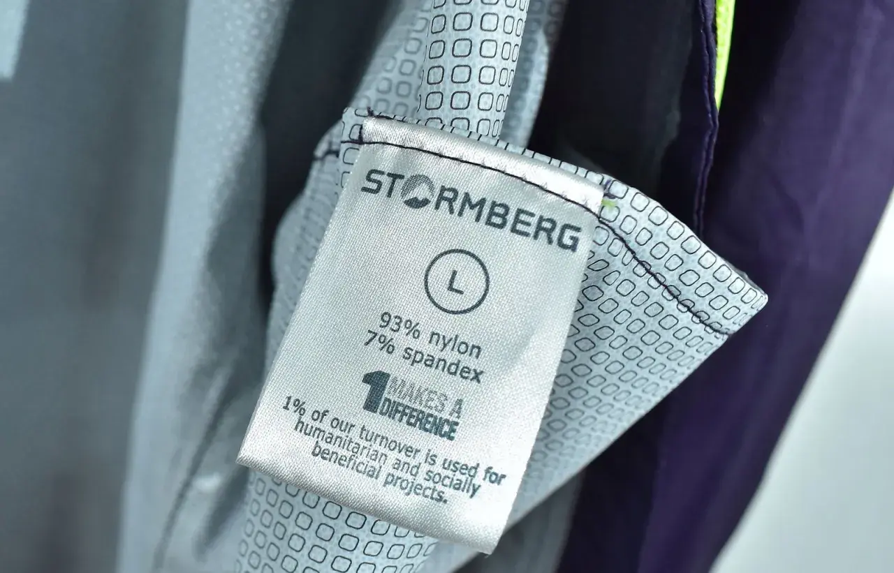 Metka odzieży marki Stormberg, firmy wspierającej projekty humanitarne. Rozmiar L, skład 93% nylon, 7% spandex.