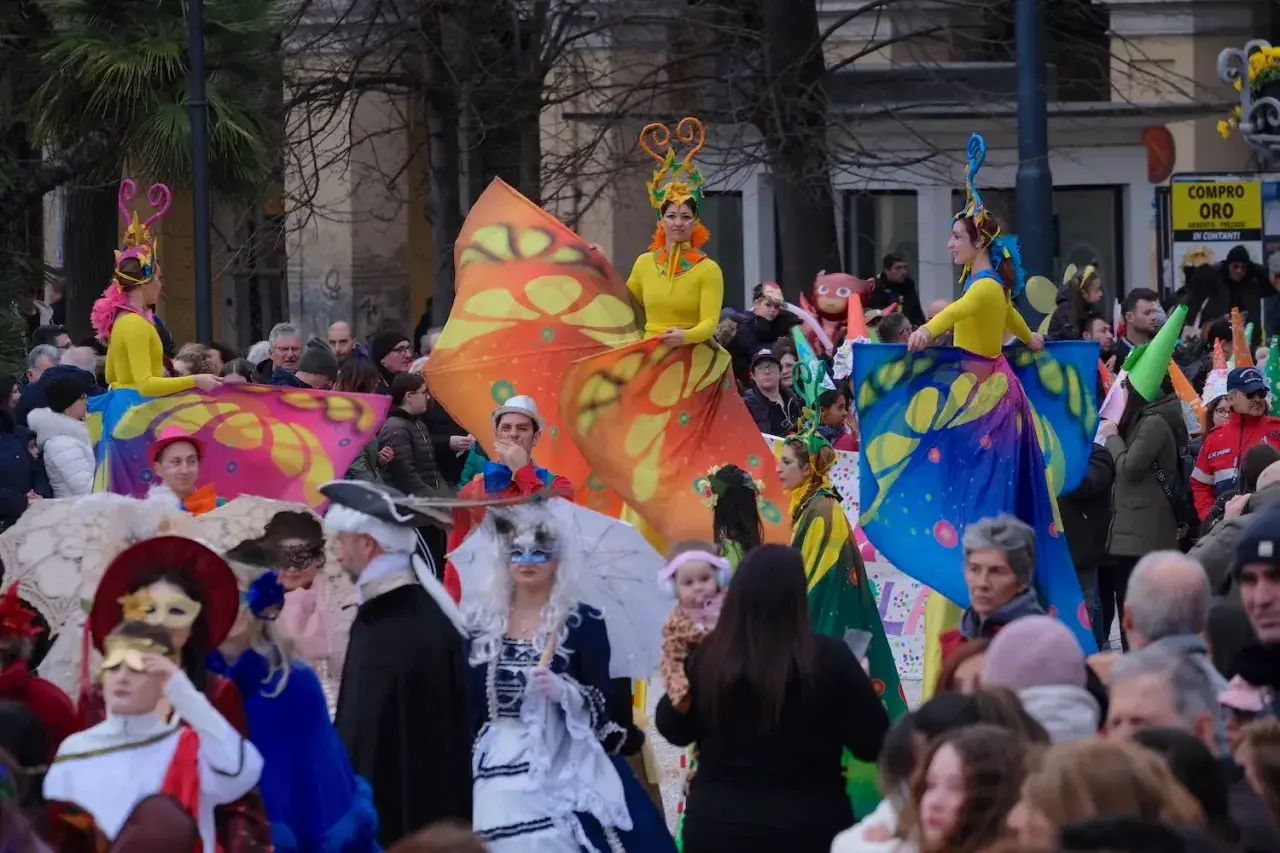 Coloratissimo carnevale ad Ancona con costumi a tema farfalla e maschere.